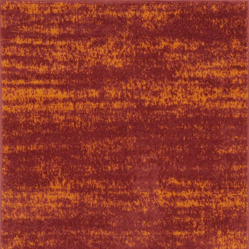 Abstract area rug close-up, maroon-red and orange speckled textured pattern