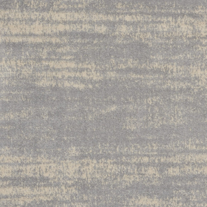 Close-up of gray and beige abstract square rug with mottled distressed pattern.