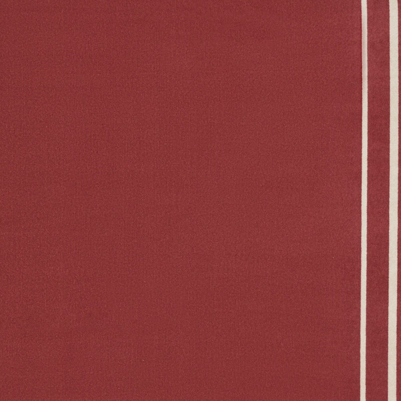 Brick red area rug with ivory outer border line, tight view of right edge