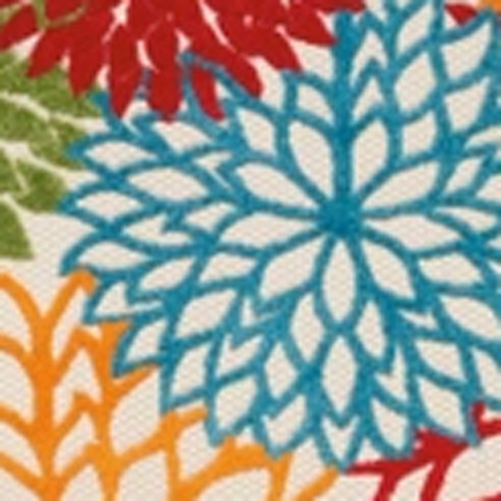 Floral runner rug close-up with blue starburst flower and red accents on cream ground.