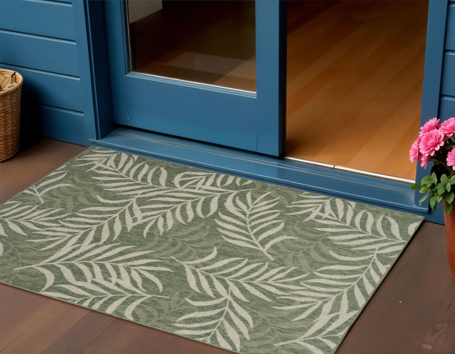 Green and ivory palm leaf indoor outdoor rug laid flat on wood floor