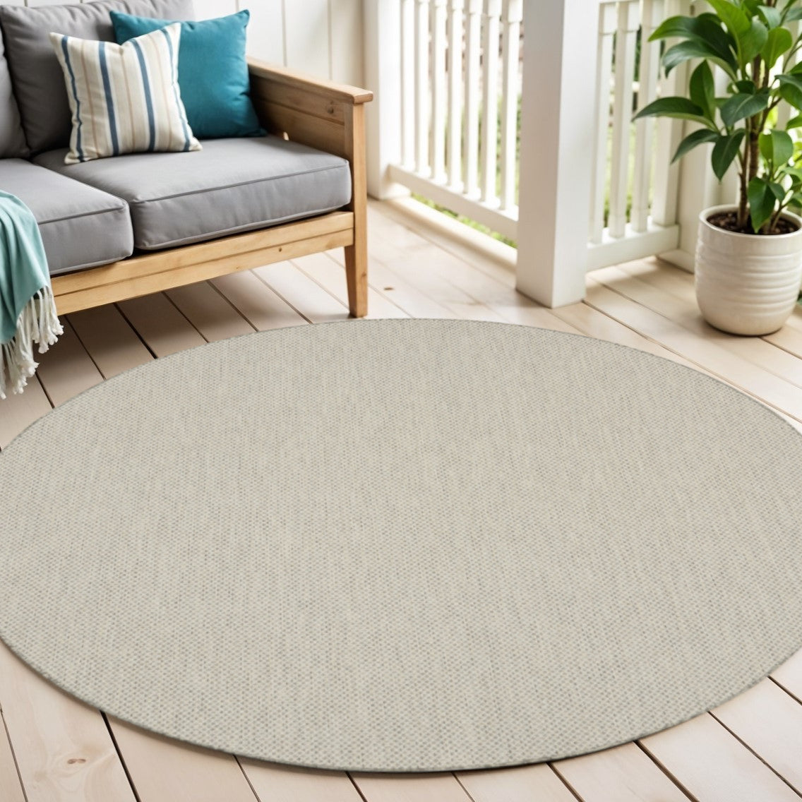 Round woven area rug in light ivory with subtle speckled texture on floor