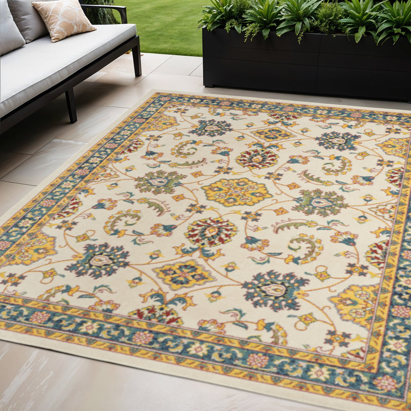 Ivory floral area rug with gold frame and blue-green scroll motifs