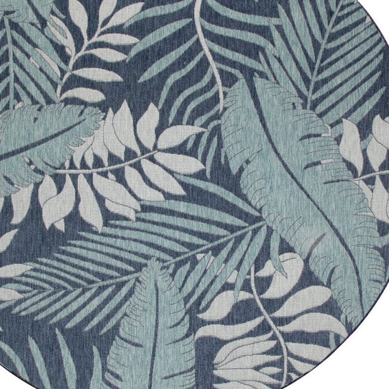 Close-up of circular rug design with navy and ivory botanical leaves