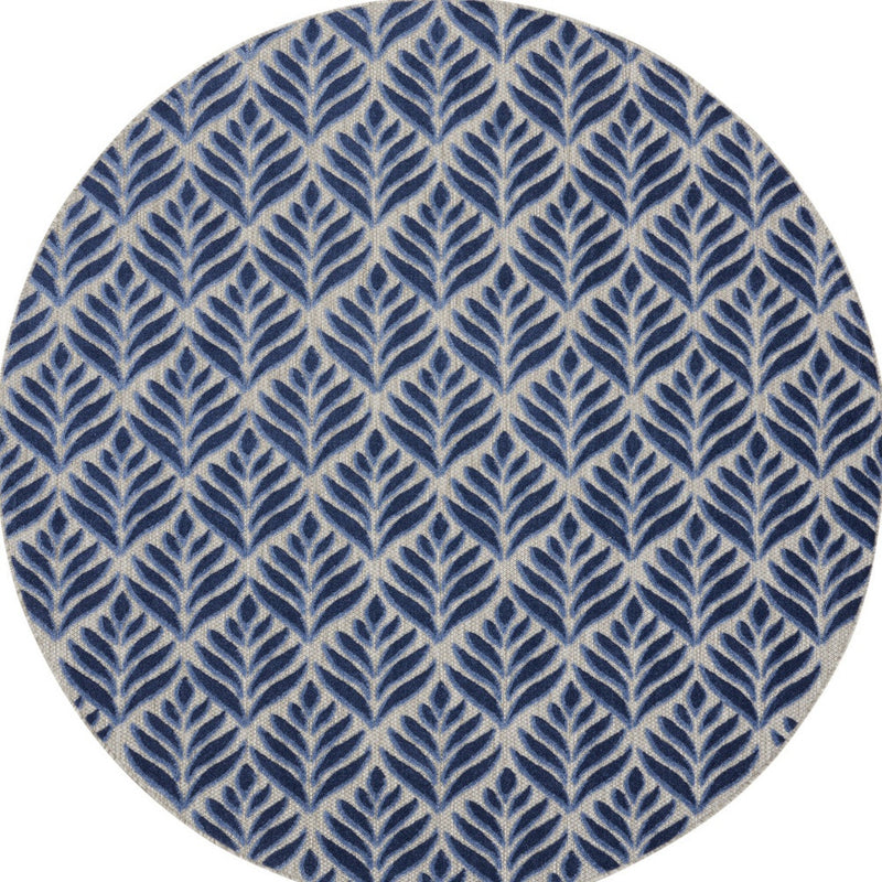 Round blue area rug with repeating leaf pattern on cream base