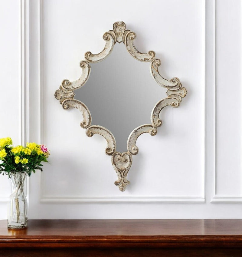 Accent mirror with distressed white ornate wood frame, carved scroll details