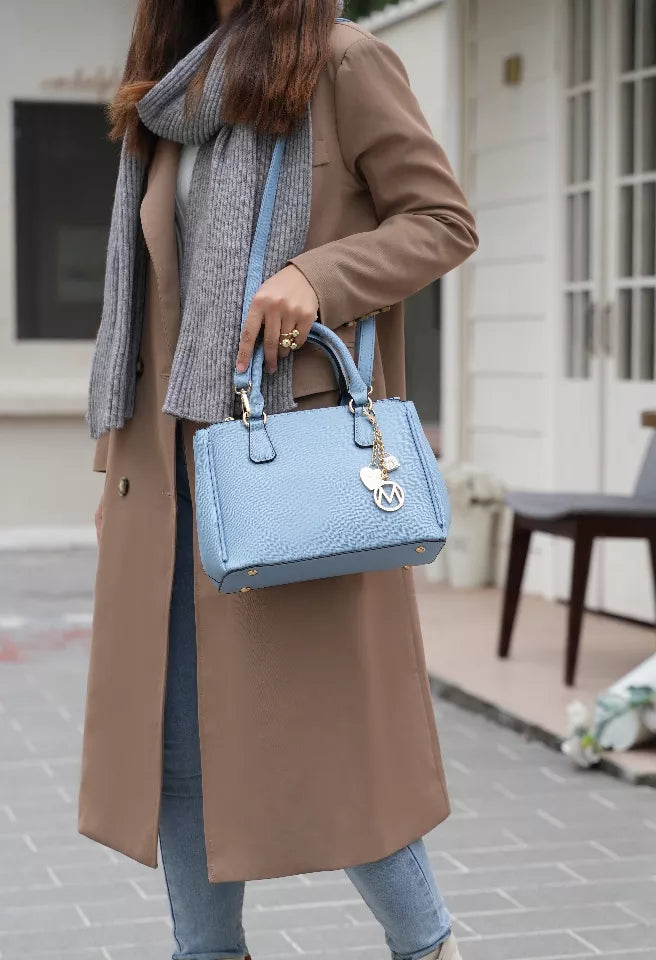 Light blue vegan leather satchel bag with two handles and chain charm; wallet pocket visible