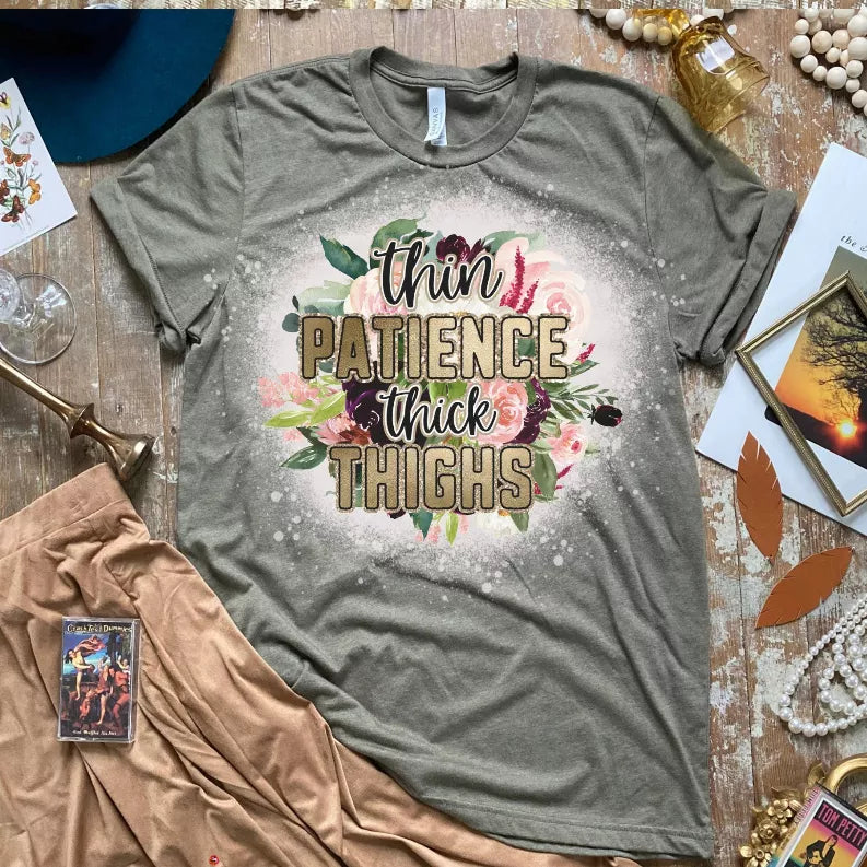Gray unisex T-shirt with centered floral 'Thin Patience' 'Thick Thighs' text graphic