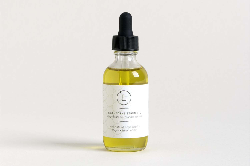 Natural beard oil bottle with black dropper and yellow-green liquid