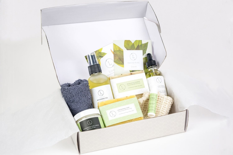 Handmade soap gift box open with soaps, bottles, and jars inside