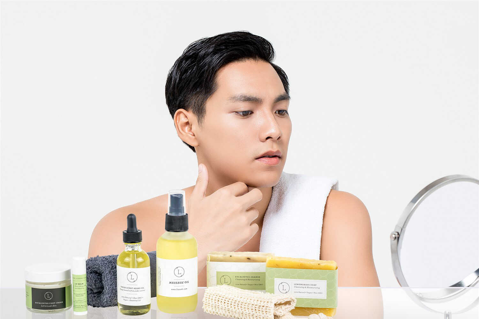 Man with towel and skincare products, including a soap bar and oil bottles