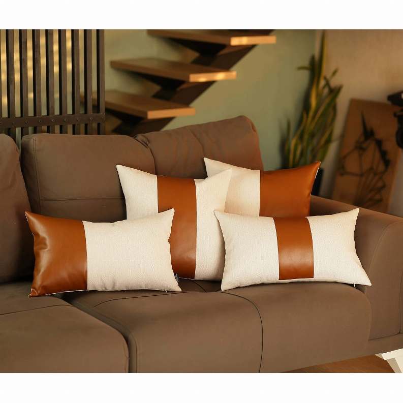Set of 4 throw pillows with orange faux leather accents and white fabric cushions