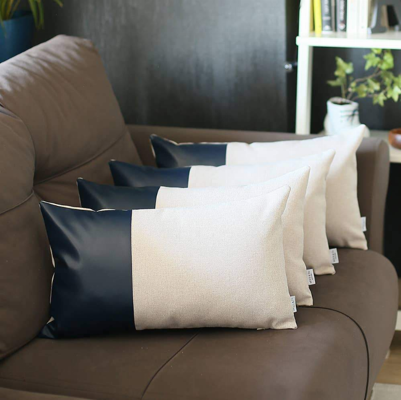 Decorative throw pillows in cream and dark navy with faux-leather center panels