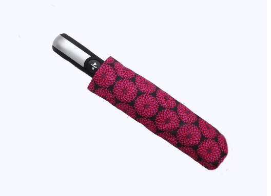 Compact umbrella, closed red fabric with dark floral pattern and silver push-button handle.