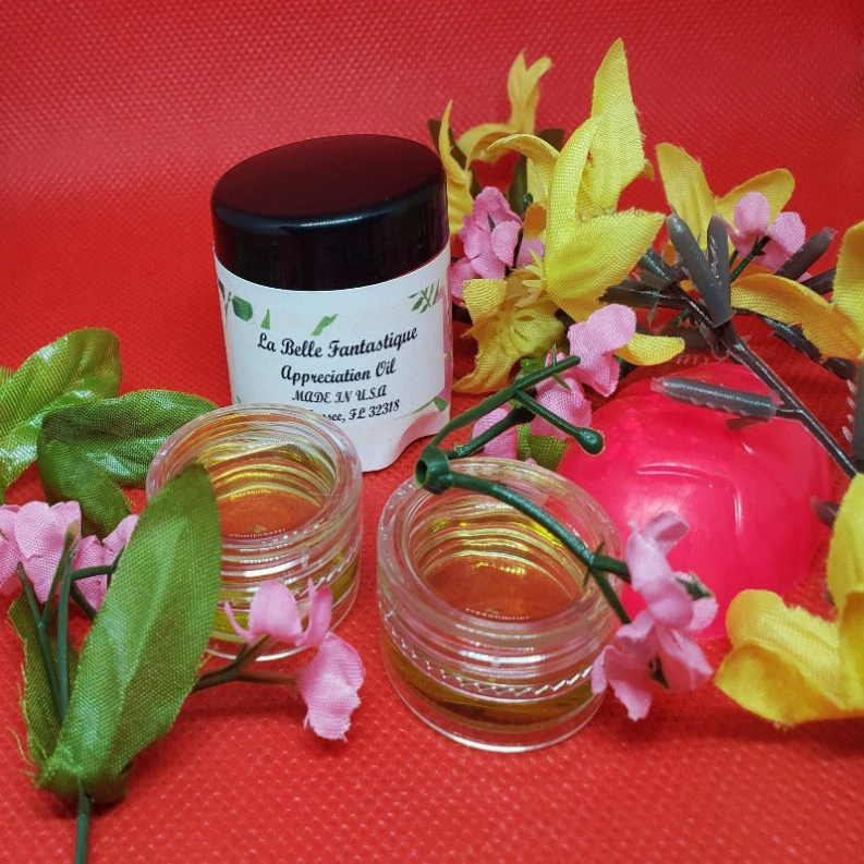 Body oil jars with black caps and amber oil, including one labeled container.