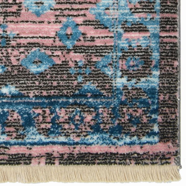 Machine woven area rug with geometric motif in blue, pink, and dark gray; beige fringe edge.