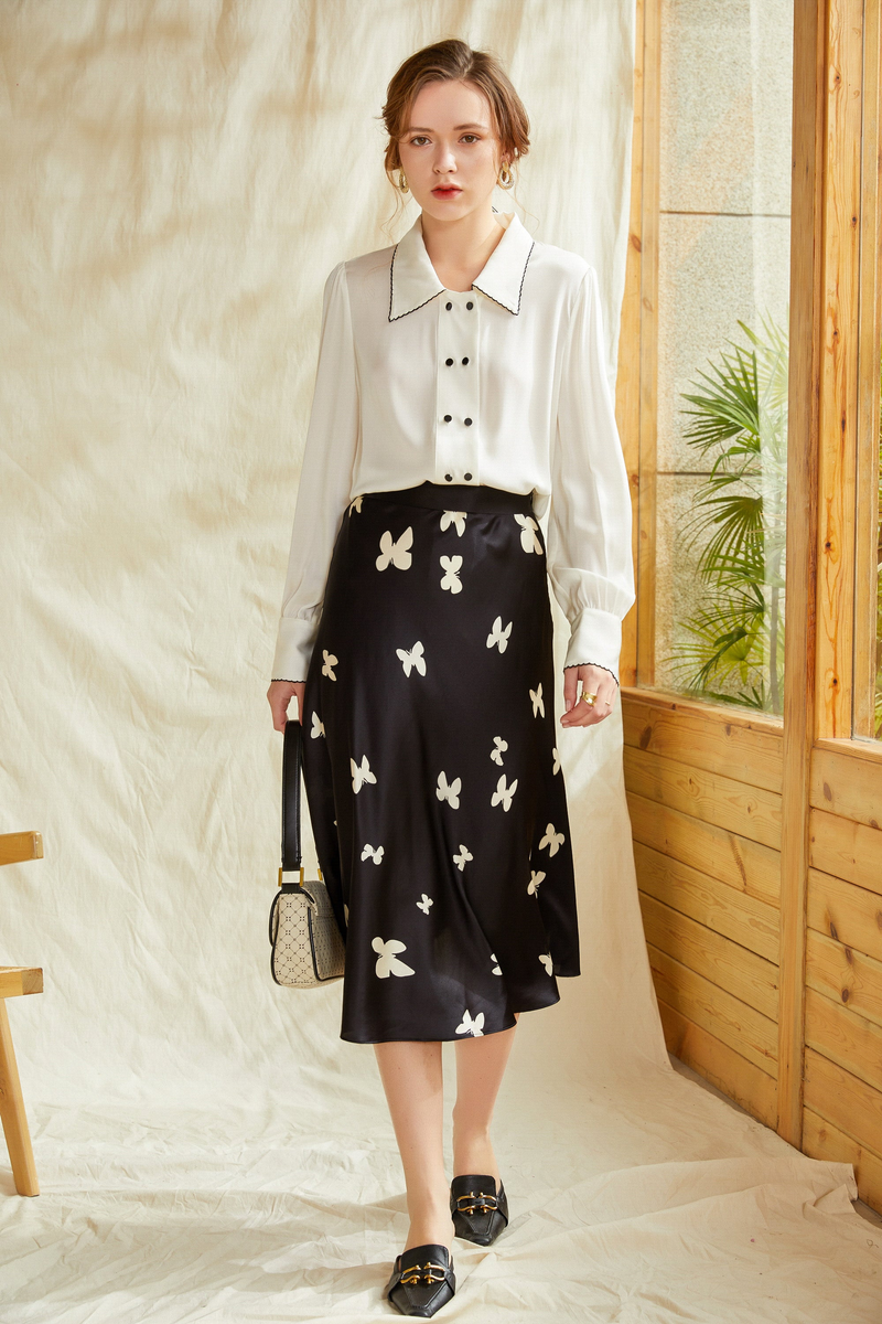 White silk shirt with pointed collar, button placket, and long cuffed sleeves.