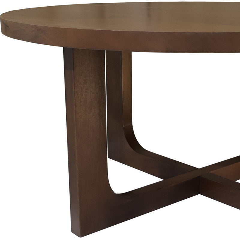 Brown solid wood coffee table leg detail with curved cross-brace under round top