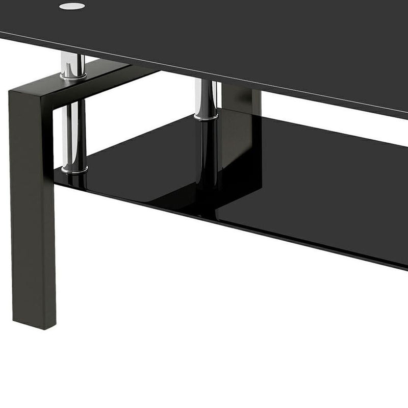 Corner view of black glass coffee table with chrome post and black base shelf
