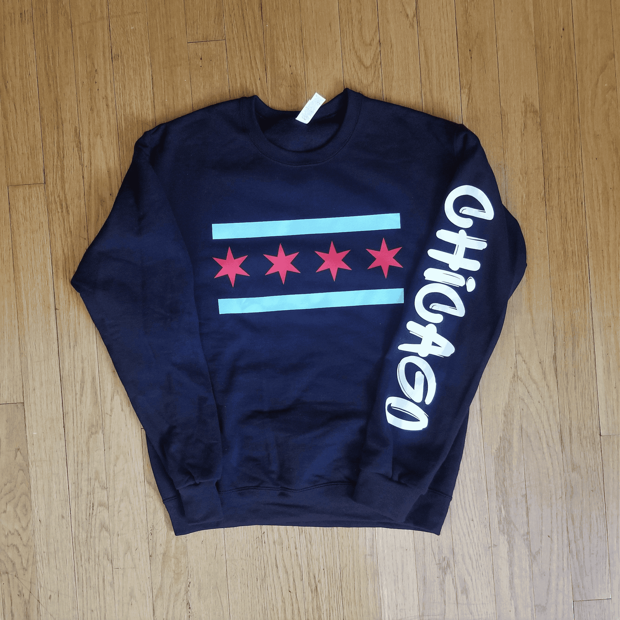 Navy crewneck sweatshirt front view with red star row, blue stripe, and white graffiti-style text