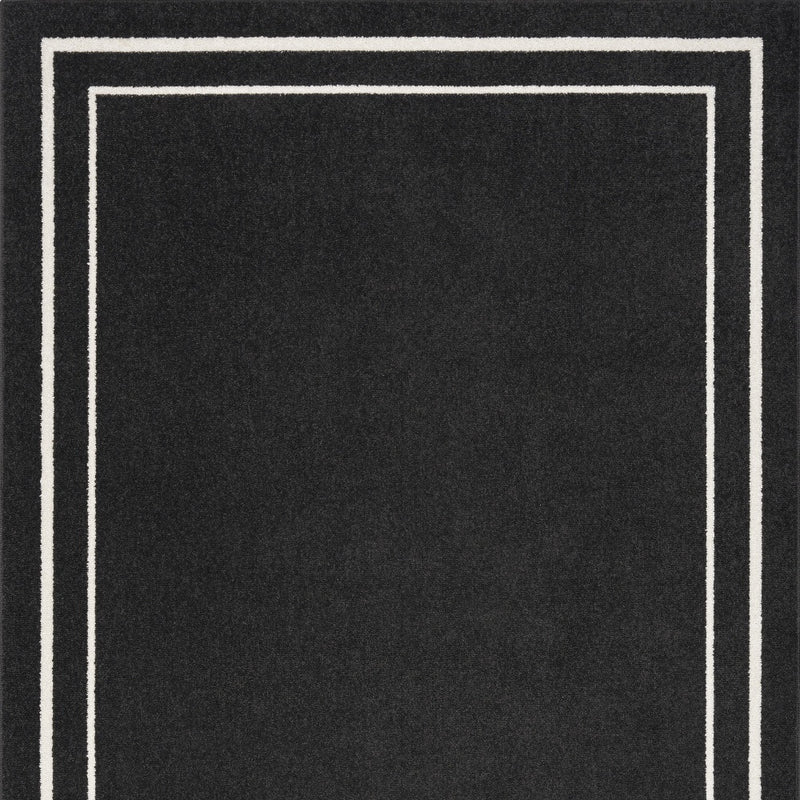 Black area rug with ivory double-square border frame.