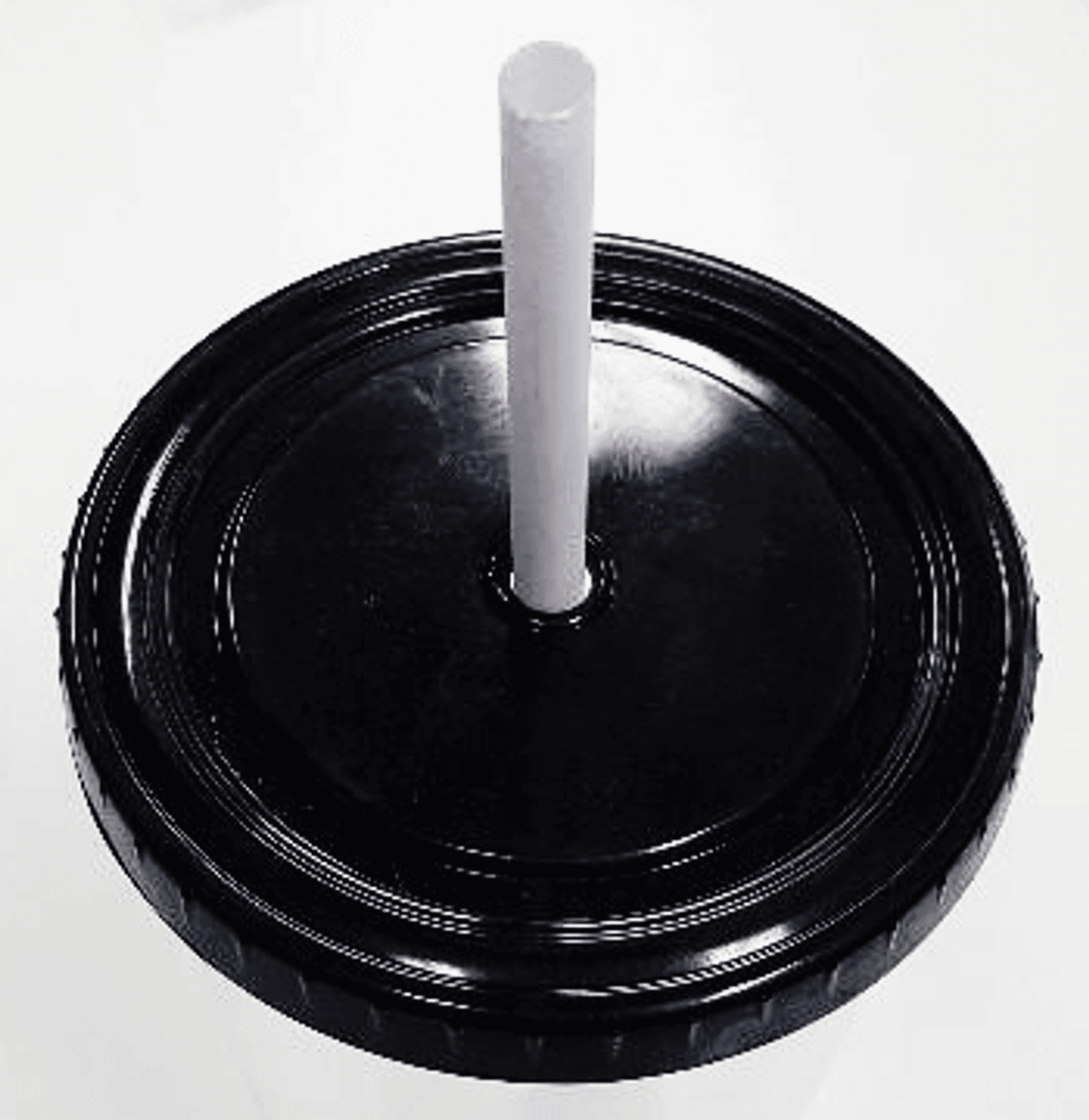 Black circular cup lid close-up with glossy texture and centered white straw