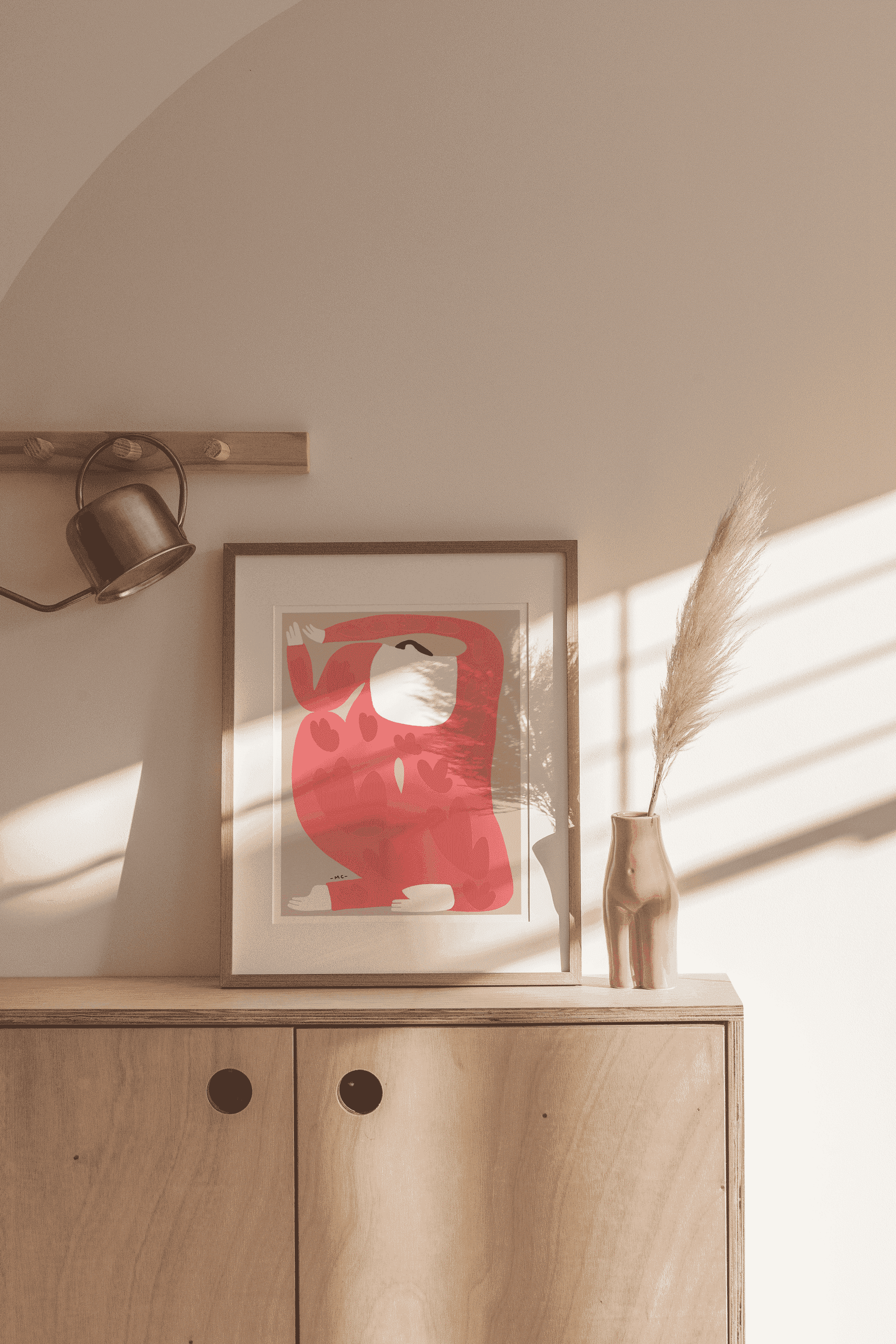 Framed wall art print with red camouflage hearts on cabinet with pampas grass and decor
