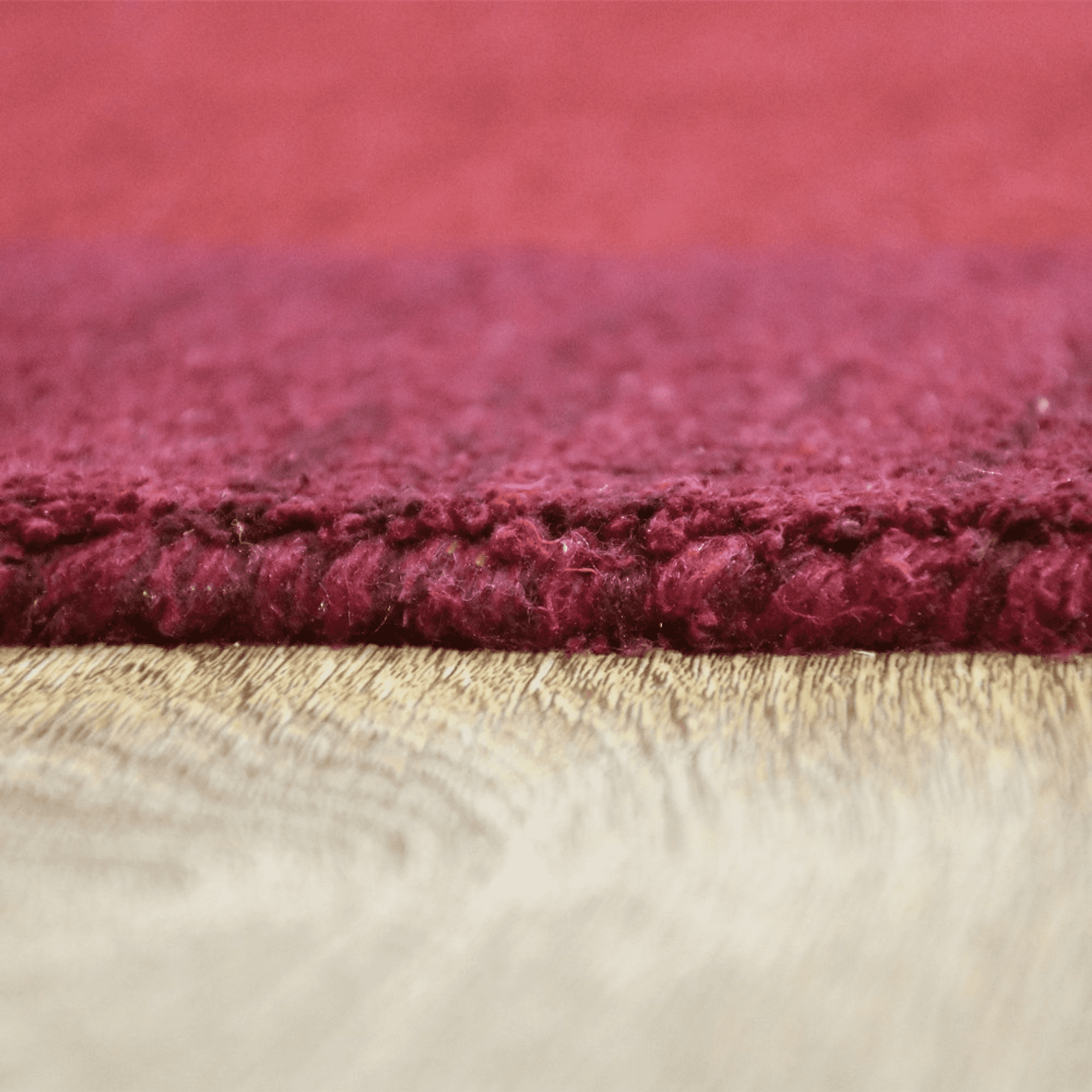 Hand-knotted silk-mix area rug, burgundy shag pile texture.