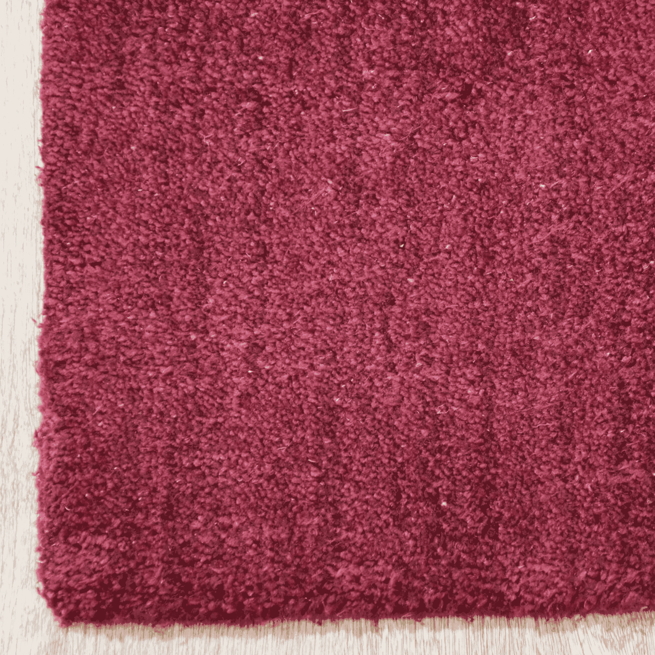 Burgundy rug close-up of dense high-pile texture along the edge.