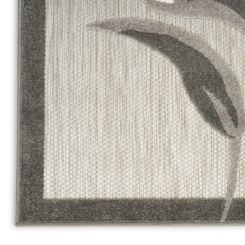 Beige floral area rug corner view with dark border and curved leaf detail