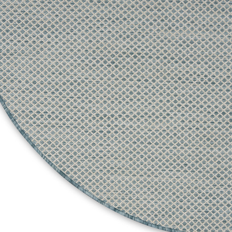 Blue geometric round rug detail view of repeating lattice pattern and braided-looking edge