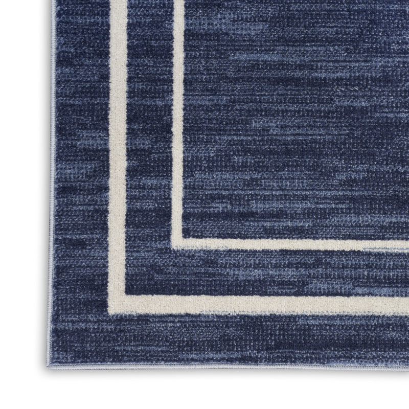 Navy rug corner with thick ivory outline border and textured weave surface