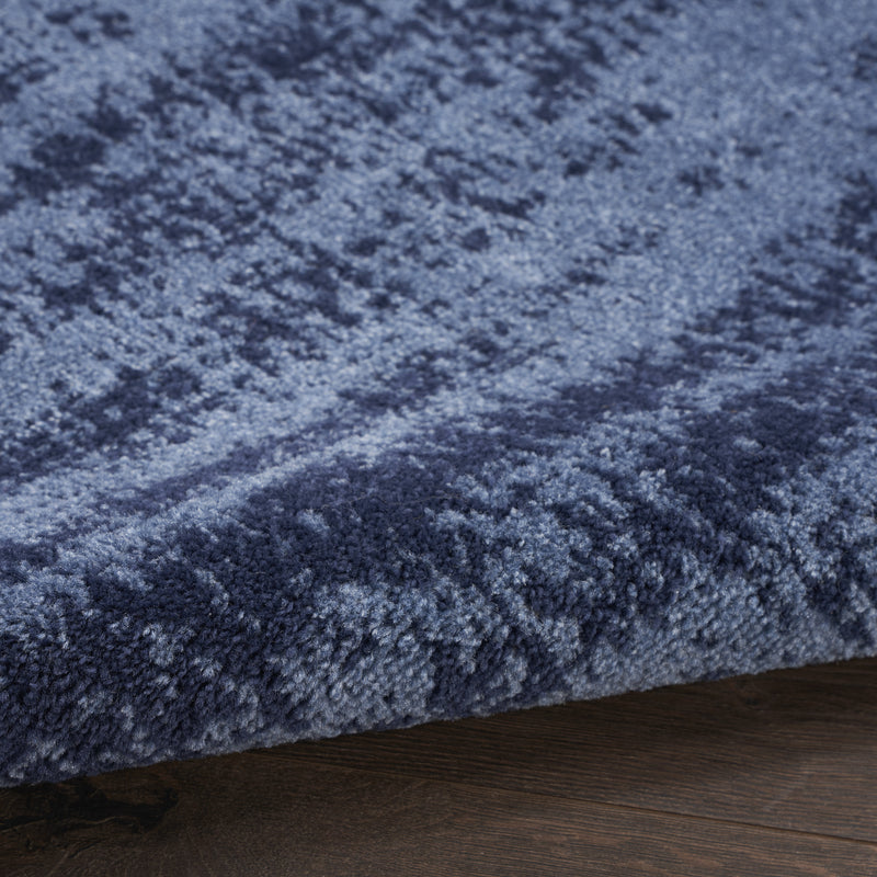 Close-up of blue abstract rug pile with textured distressed pattern