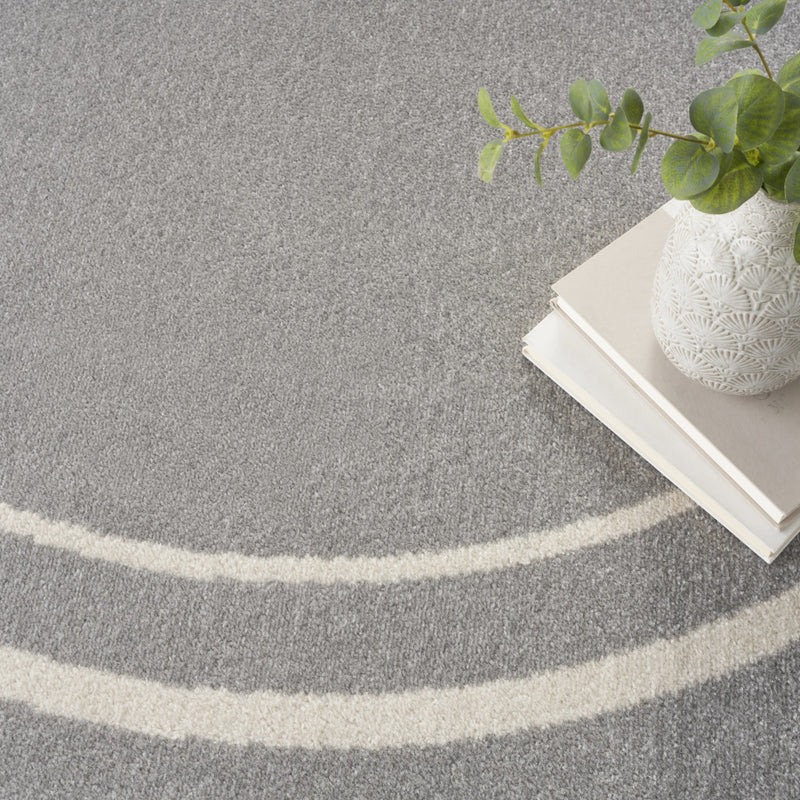 Gray round area rug corner with ivory curved stripe border and textured surface