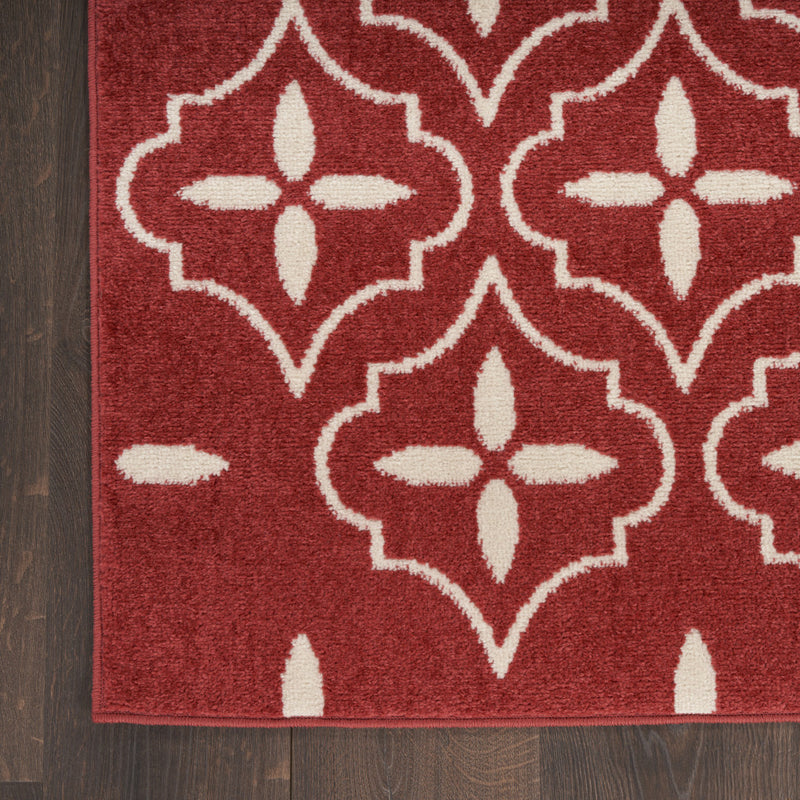 Brick red and ivory geometric area rug with repeating eight-point star medallion pattern.