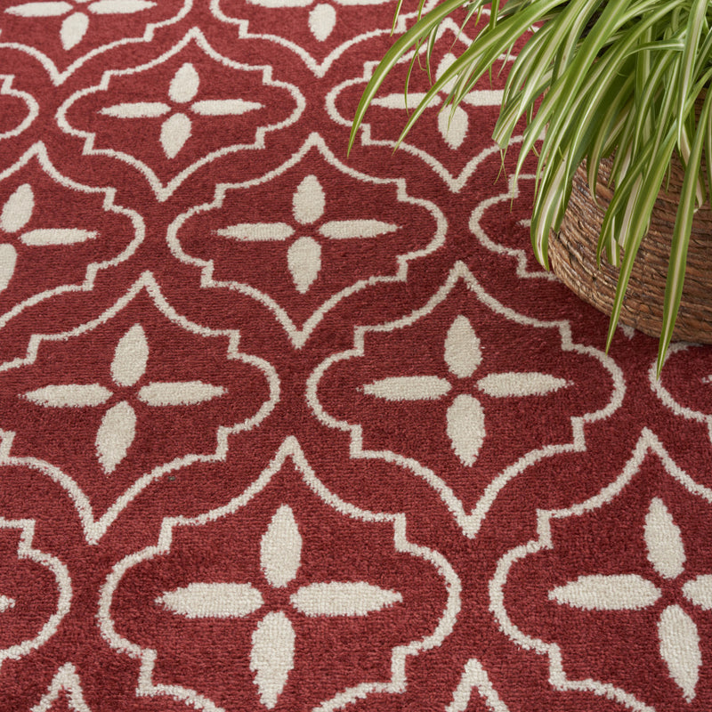 Brick red and ivory geometric area rug with repeating quatrefoil star motifs.