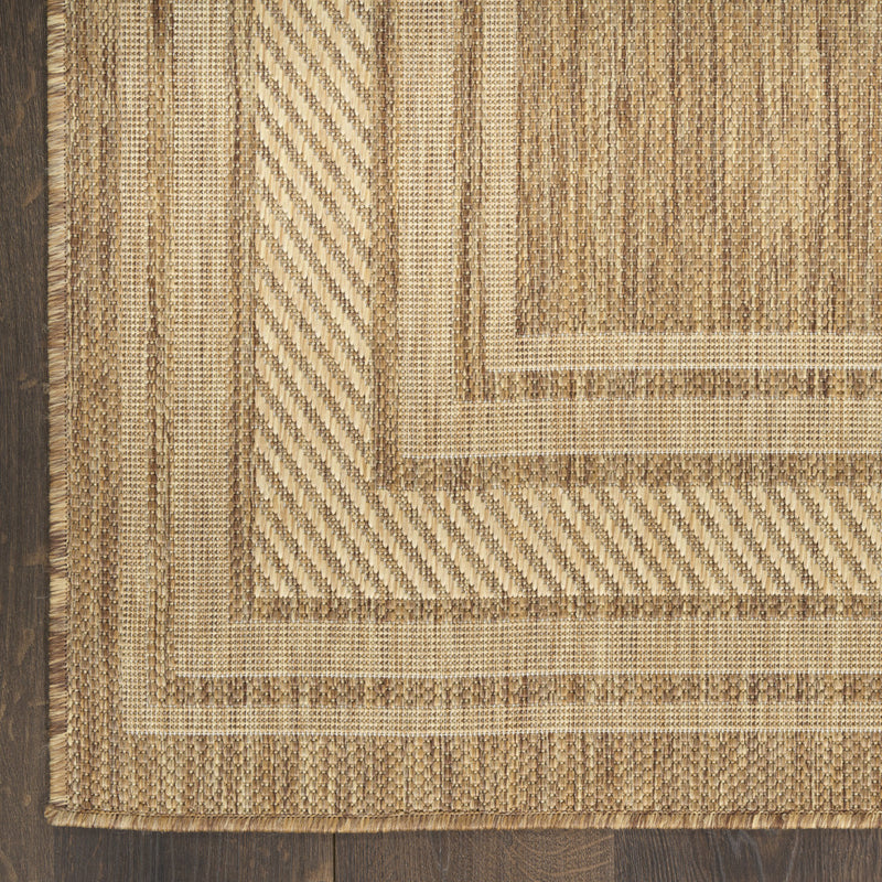 Natural geometric area rug corner with layered beige and tan border trim