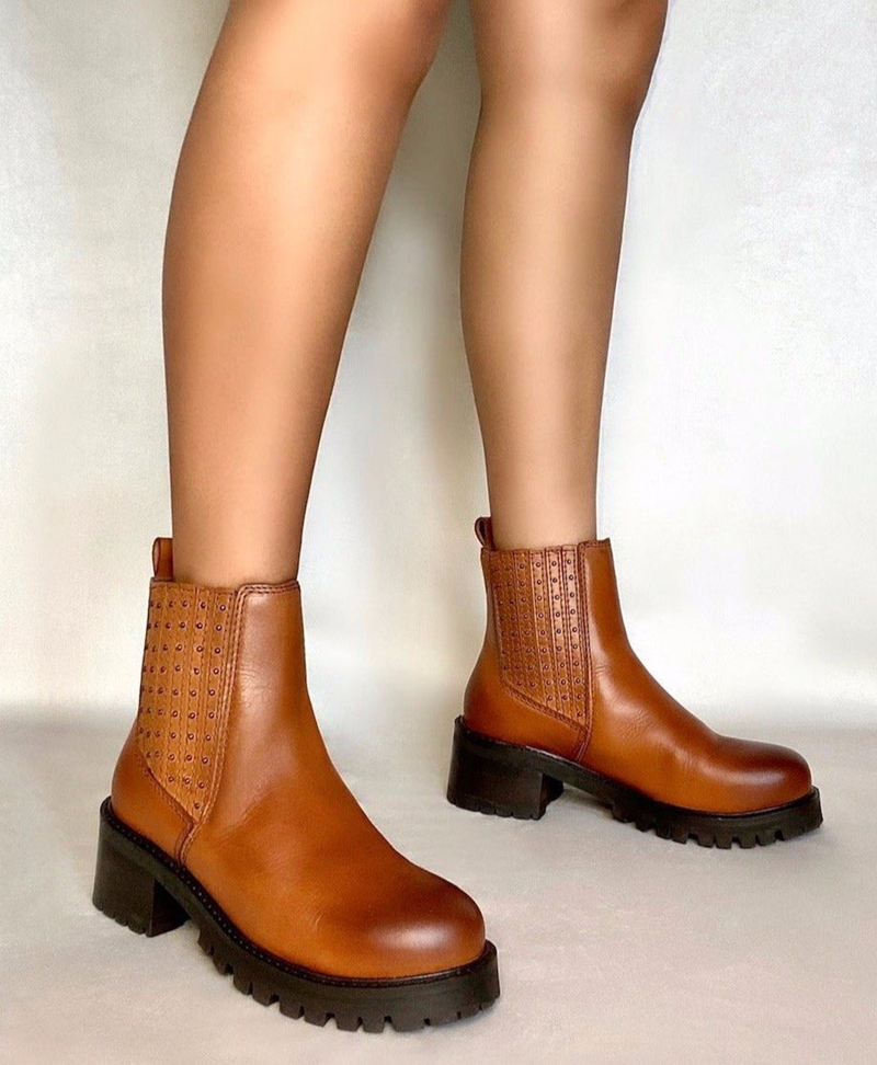 Tan Chelsea boots on block heel with studded elastic panels, worn with bare legs