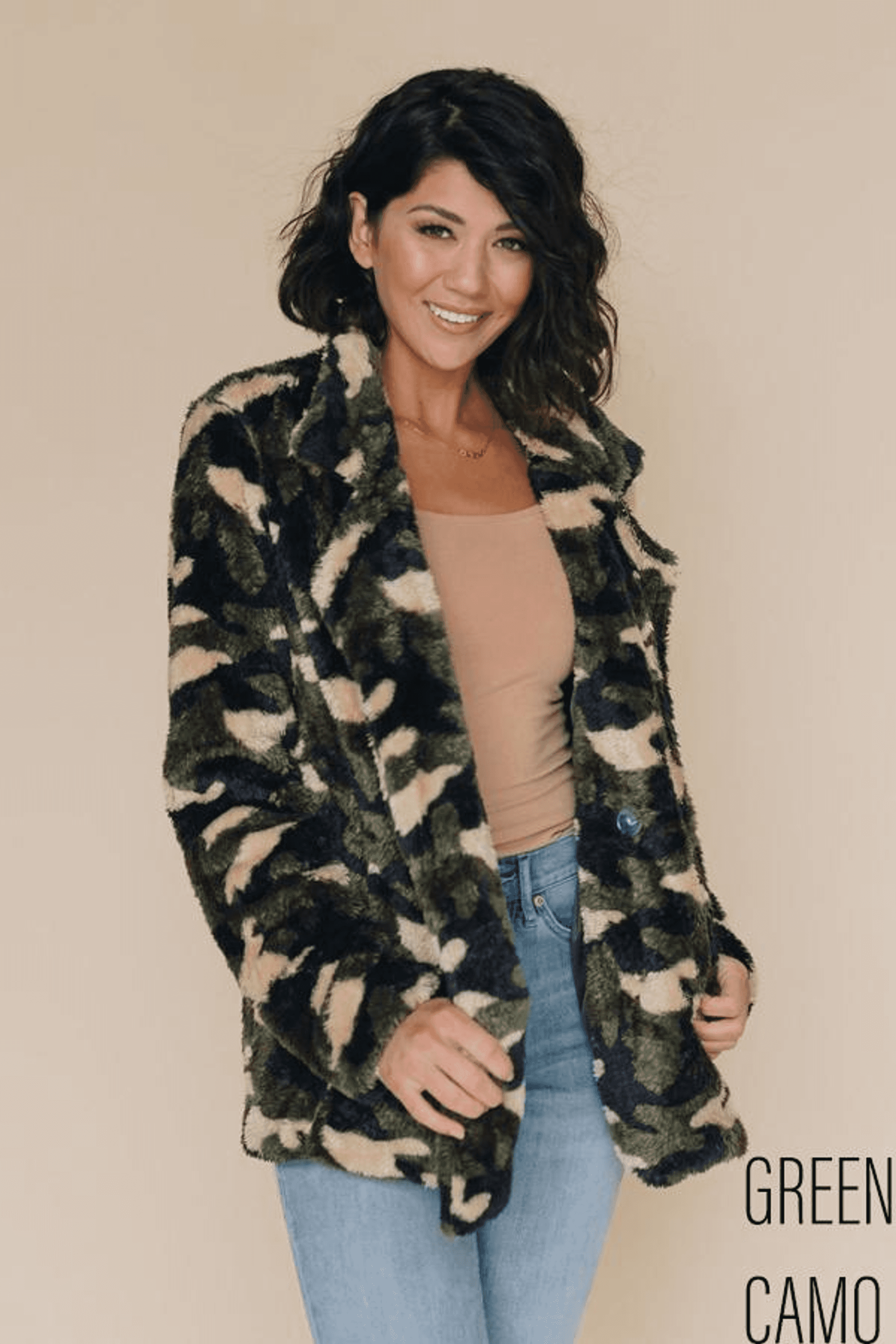 Front view of hooded camo fleece coat worn over a tan top and blue jeans