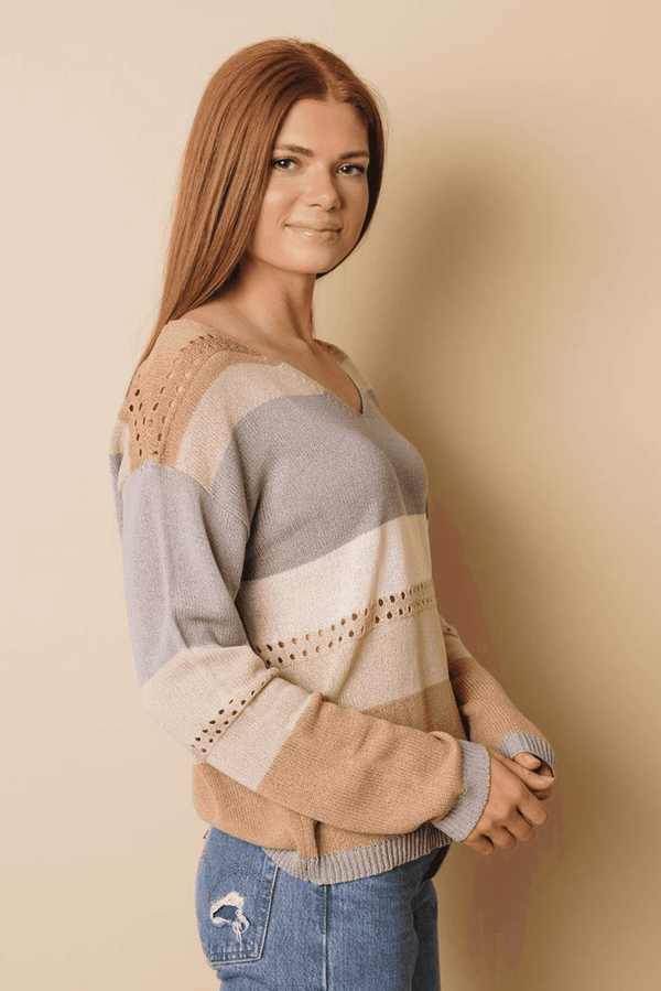 Side view of knitted color block sweater, V-neck style, striped panels, ribbed cuffs
