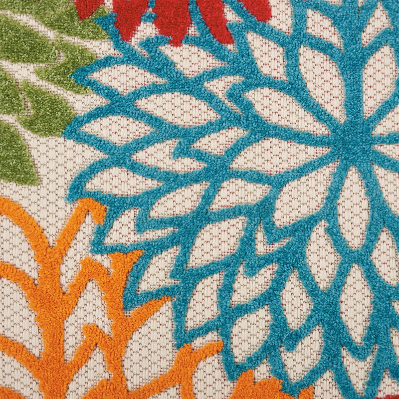 Floral runner rug close-up with blue starburst, teal outlines, cream texture, and orange accents.