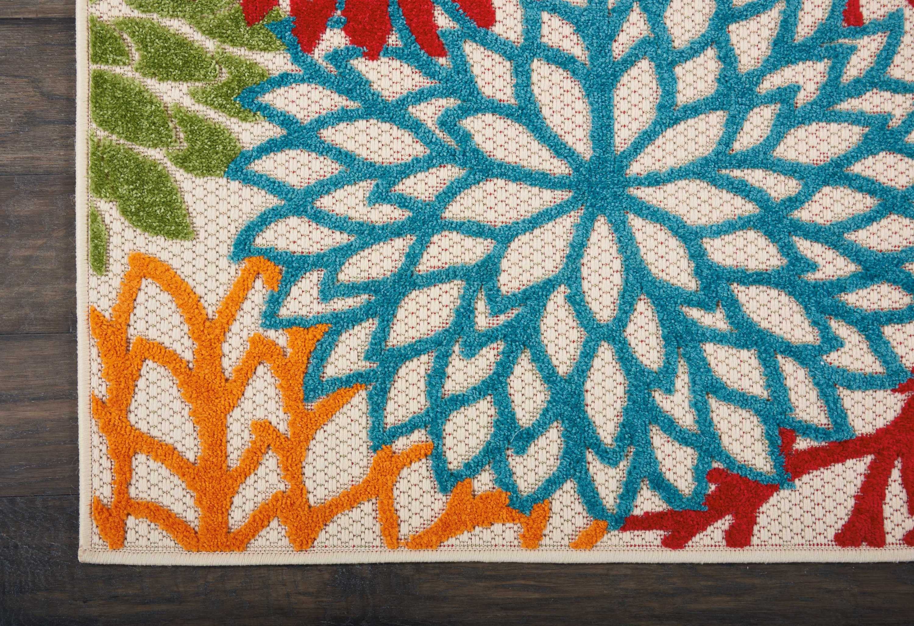 Floral patterned runner rug with large blue teal bloom, orange and red accents on cream ground