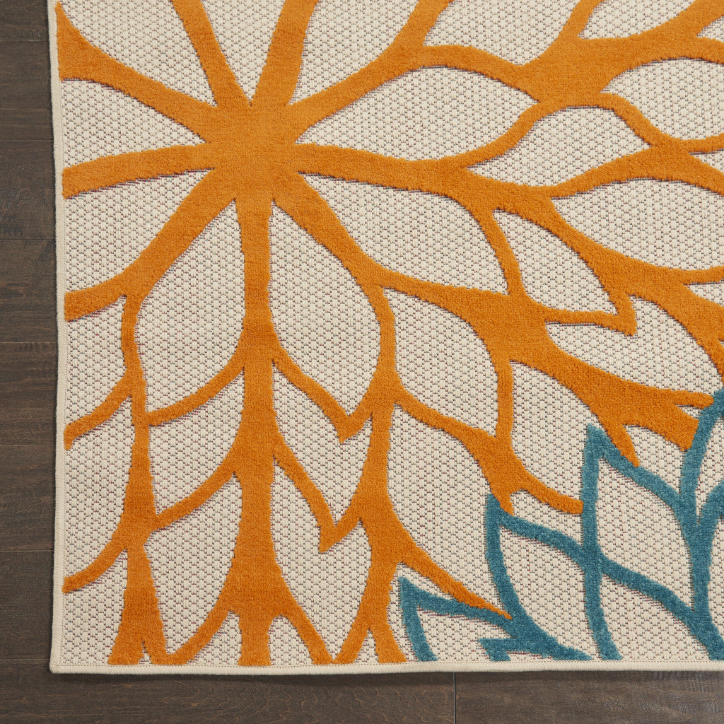 Ivory floral area rug with orange sunburst and blue vine accents across the surface