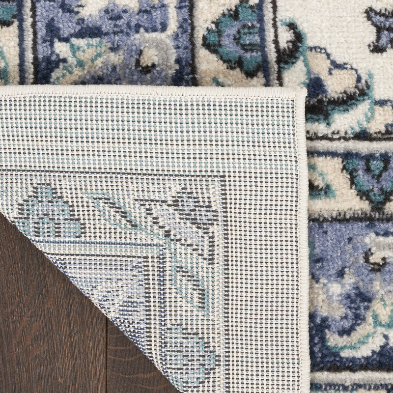 Ivory rug edge with woven backing and blue geometric motif