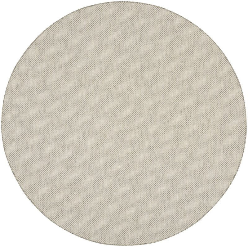 Round ivory rug with subtle silver-tone geometric lattice pattern, flat woven face