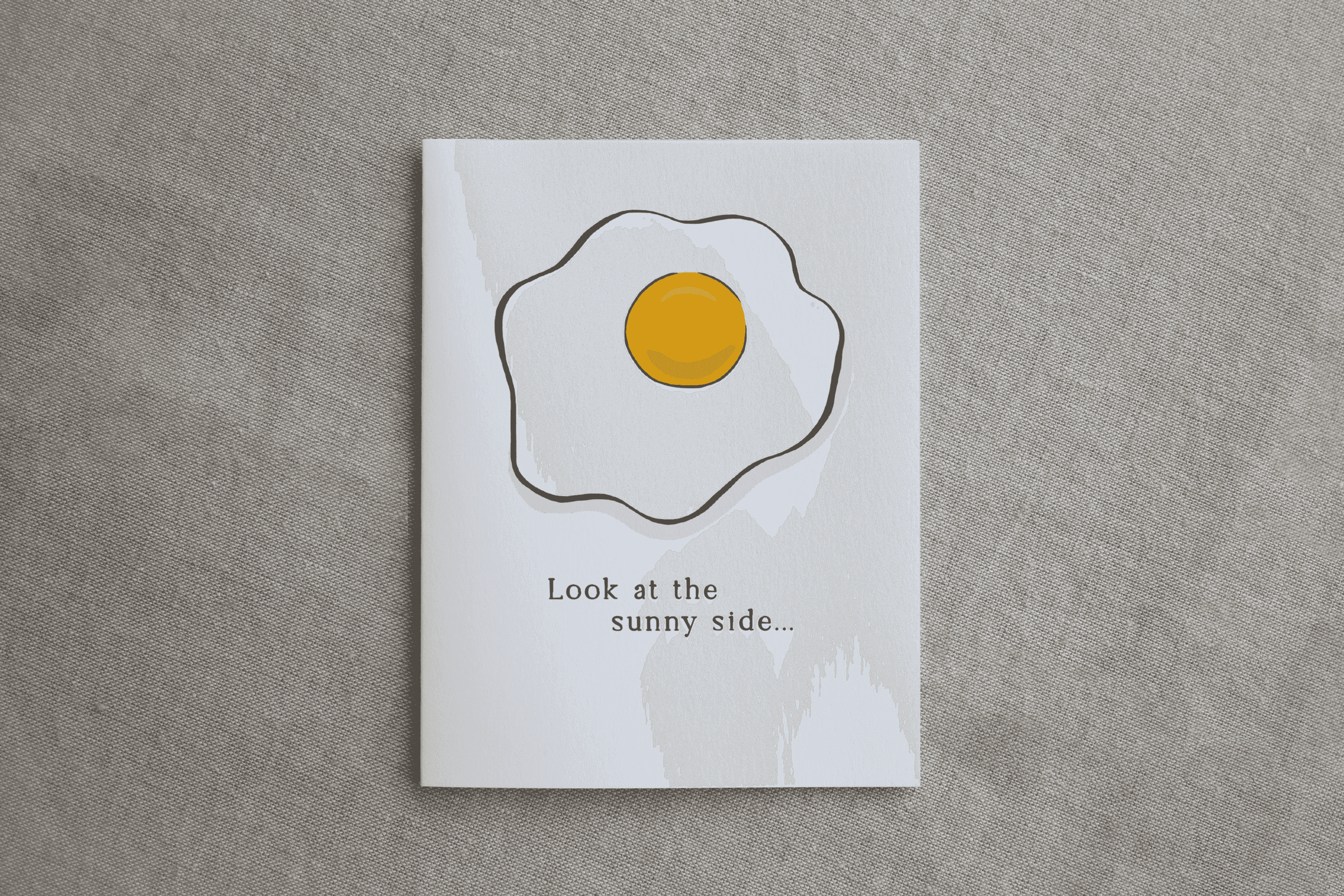 White greeting card with sunny-side egg graphic and 'Look at the sunny side...' text