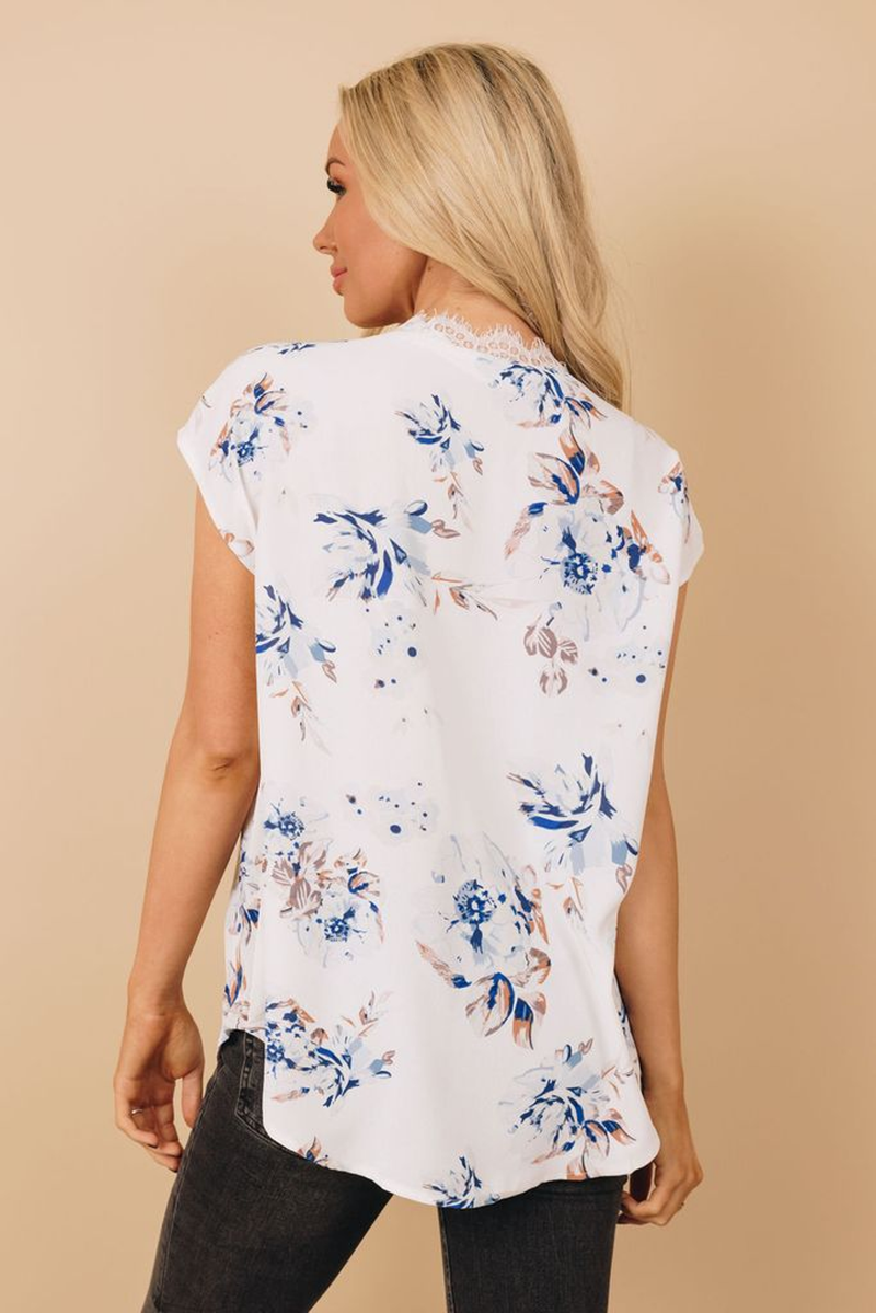 White floral print top with short sleeves and back view, curved hem