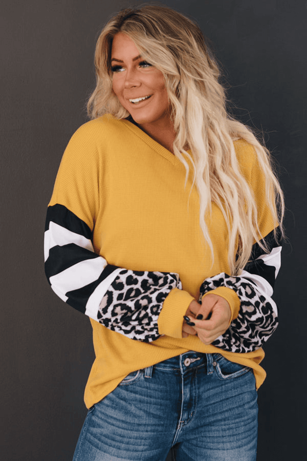 Yellow striped top with black-and-white sleeves and leopard print cuffs