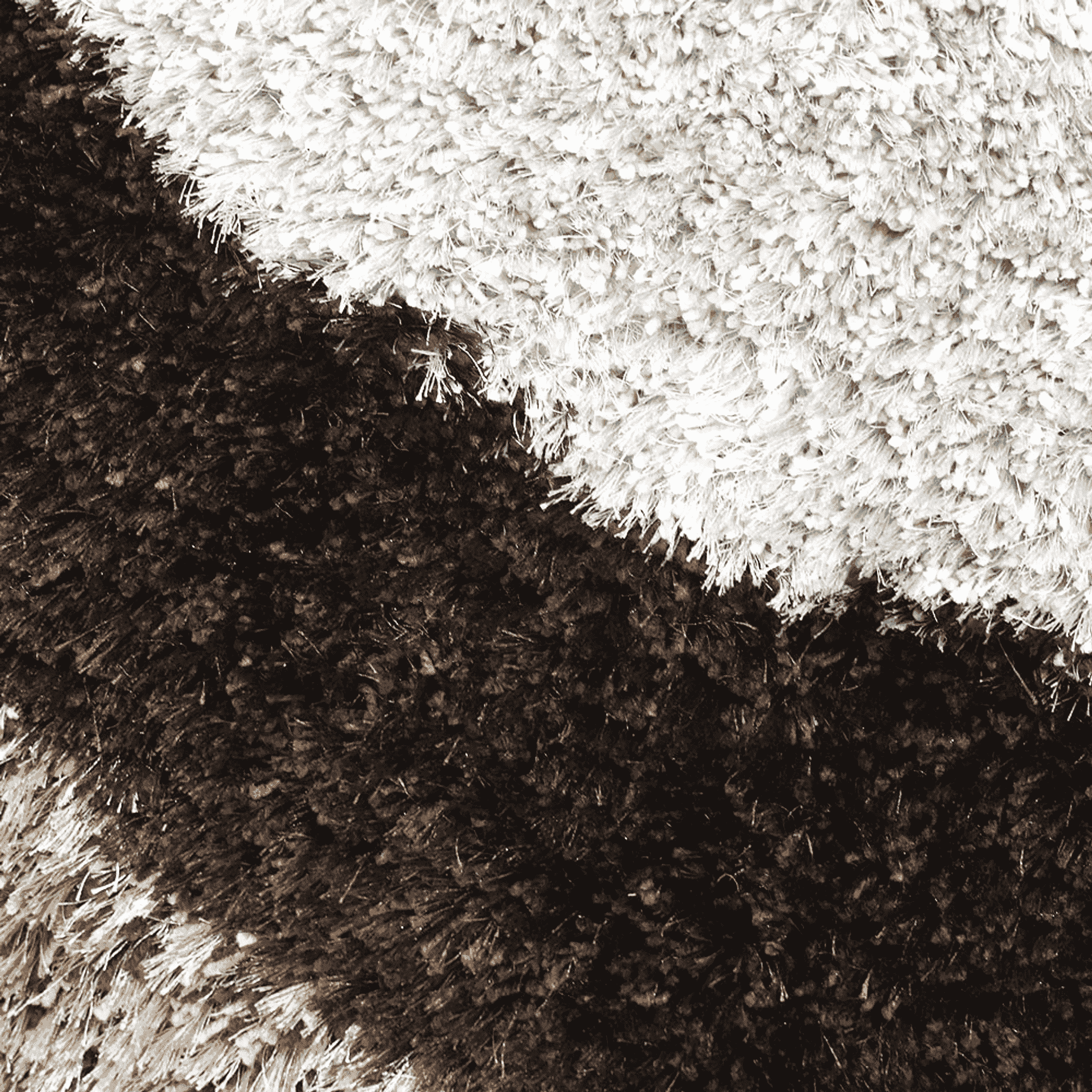 Close-up of shag rug pile showing white and dark brown fiber contrast