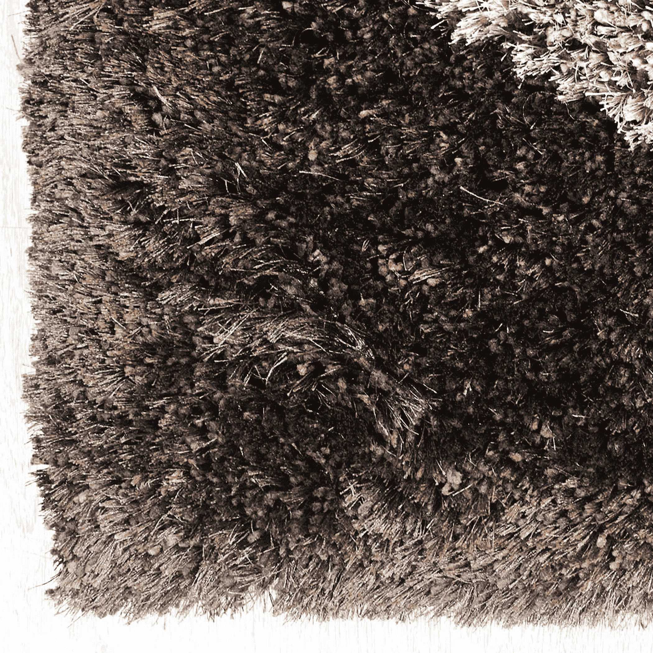 Shag area rug corner closeup with dark brown and tan fibers